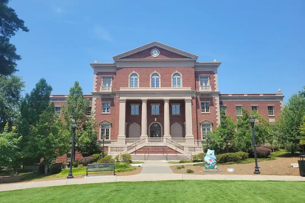 Alpharetta City Hall, a red brick building with columns, behind a green lawn in Alpharetta, Georgia