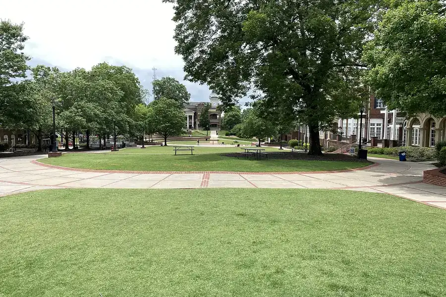 Open lawn with shade trees and paved paths in downtown Duluth, Georgia