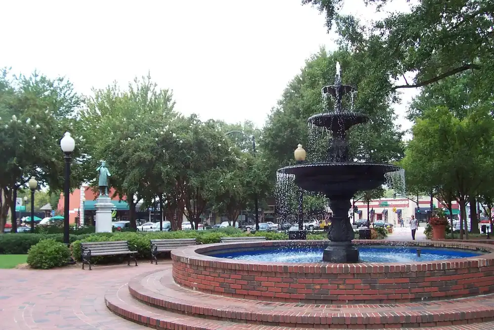 Brick fountain with trees and lamp posts in Glover Park on the town square in Marietta, Georgia