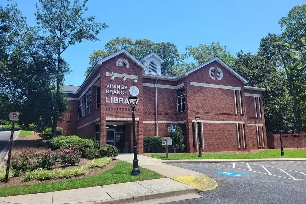 Vinings Branch Library, a red brick building with a gabled entrance and parking, in Vinings, Georgia
